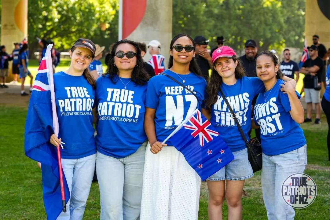 可能是包含下列内容的图片：一人或多人和上面的文字是“TRUE TRUE PATRIO PATRIOT NUEPATRIOTS. AUEPATRIOTS.ORG.NZ ORG TRUEPATRIOTS.ORA OEA NZ NZ KEEP NZ KAWIS TMIS FIRS TRUEDATRIONO FRUEBATNONOA-4L poH TRUFPA * DST Np TRU PATRIOTS OFNZ”