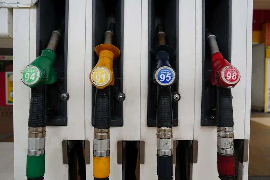 Fuel pumps and screens depicting prices for petrol and diesal at a service station.