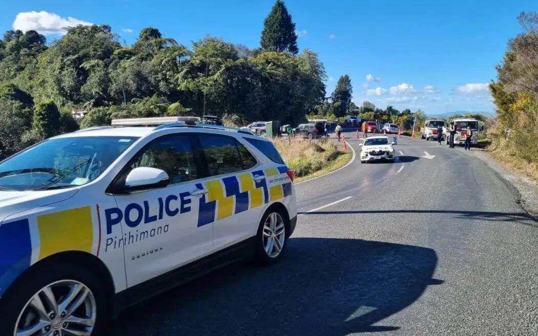 Police cars head through the cordon at Te Anga Rd.