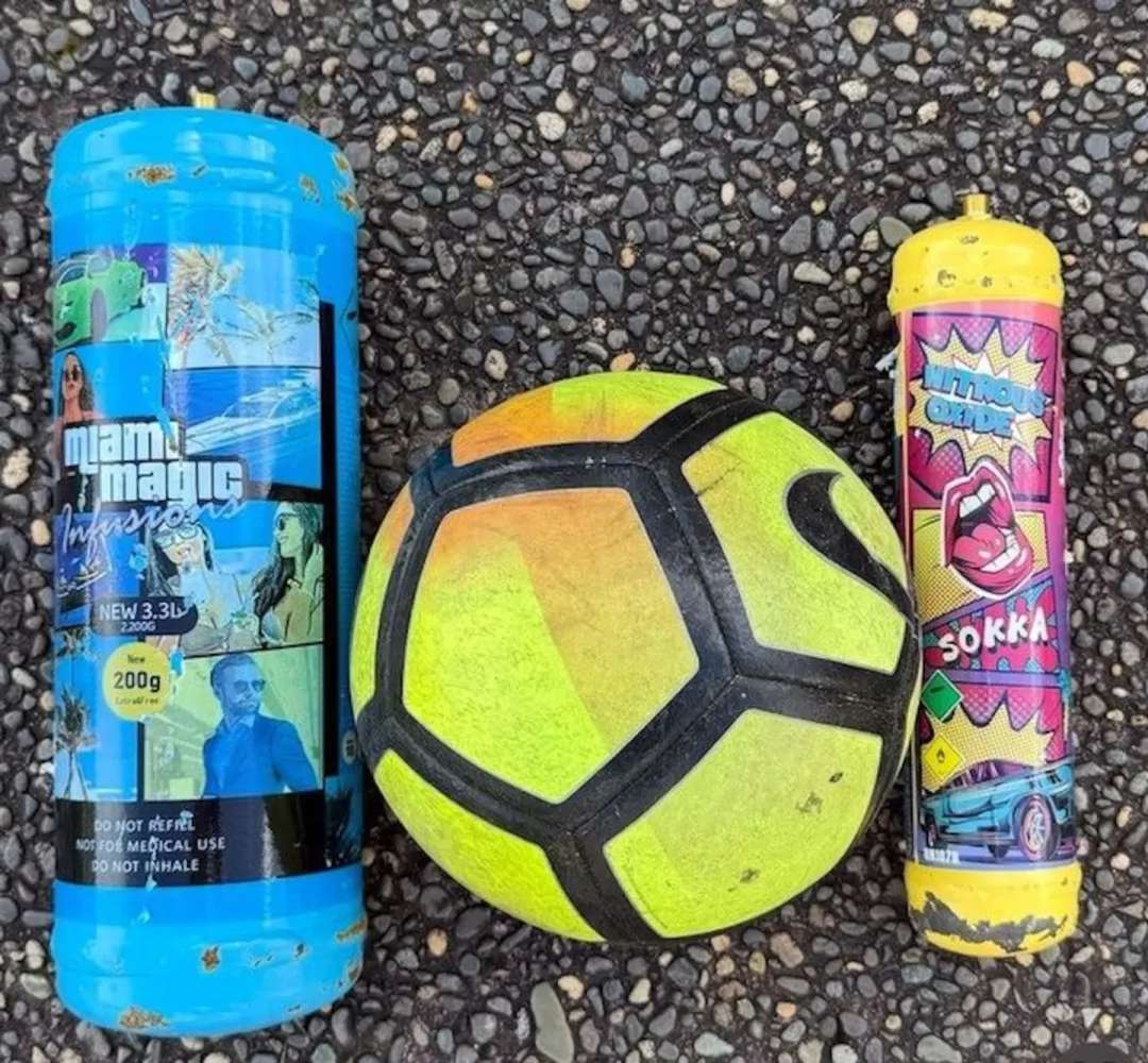A 30-centimetre nitrous oxide canister placed beside a soccer ball shows the scale of bottles now appearing on Manurewa streets.